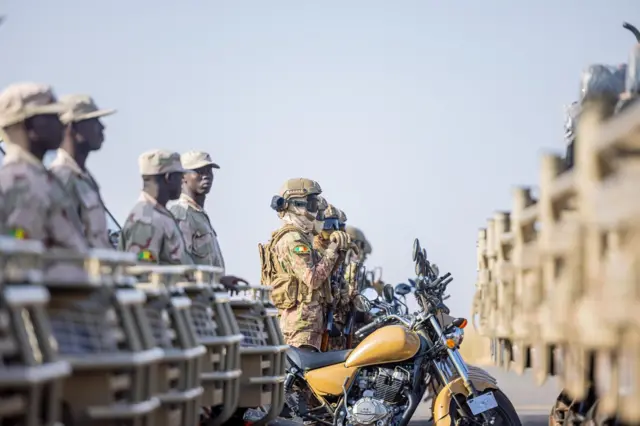 Soldats de la Force unifiée de l'AES en opération avec des véhicules militaires.