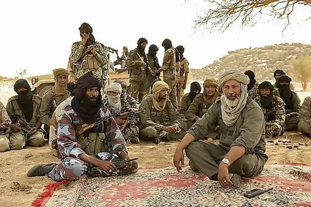 Combattants touaregs en réunion sous un arbre dans le désert malien