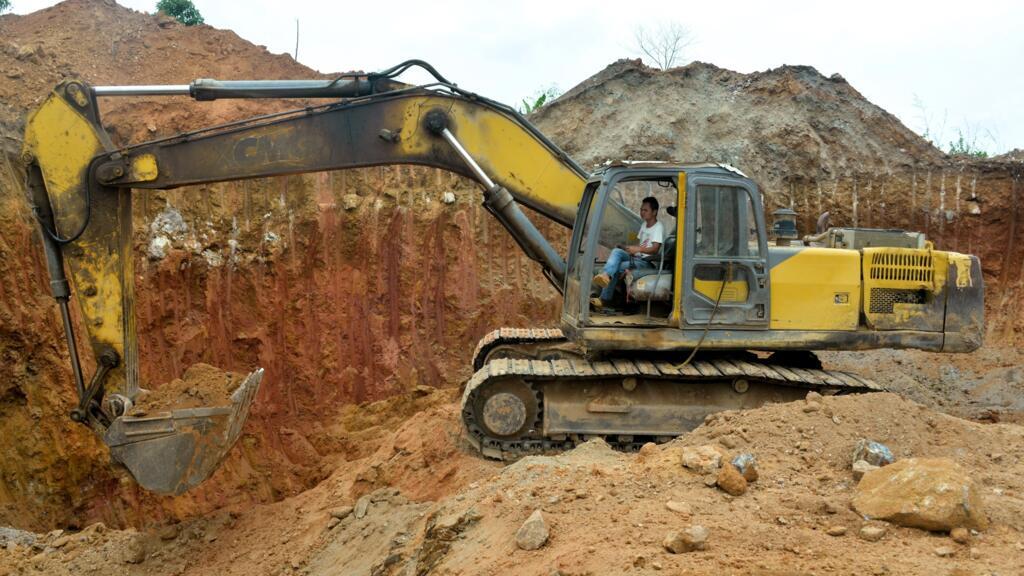 Un employé chinois d'une société minière conduit un bulldozer sur un site aurifère à Betare Oya, au Cameroun, le 4 avril 2018.