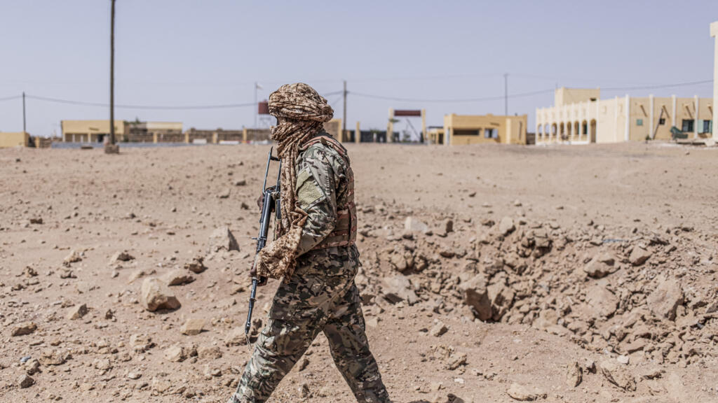 Un soldat inspecte un cratère issu d'un bombardement aérien à Kidal, au Mali, illustrant les tensions sécuritaires dans la région.